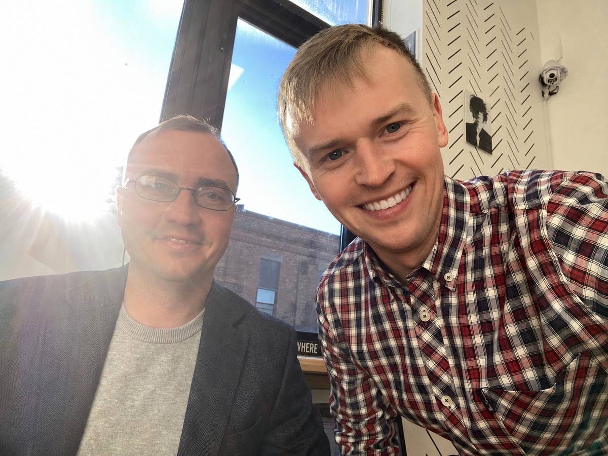 Two of the Fluvius team at a client's office in New York, brick buildings through the window behind them