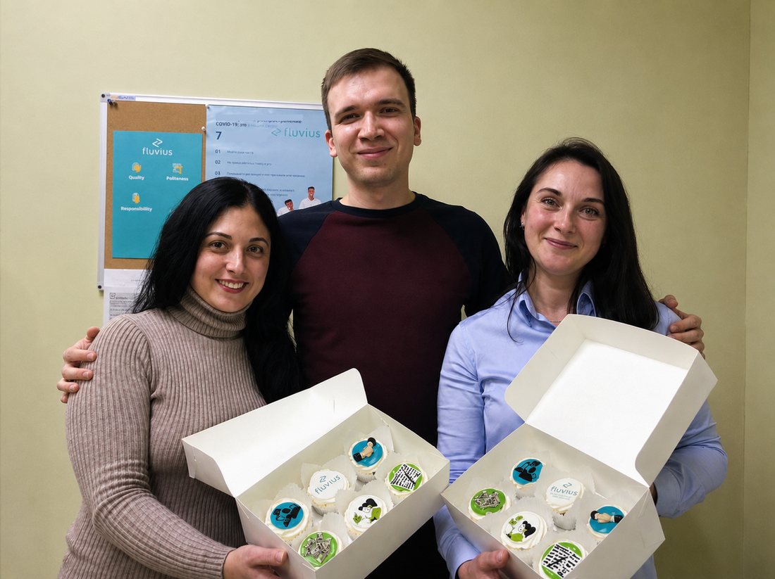 Three of the Fluvius team in the office holding boxes of Fluvius-branded cupcakes