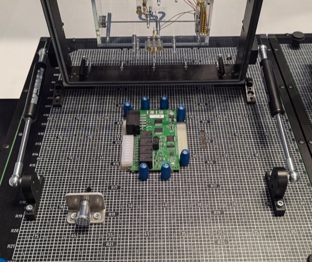 A board clamped in a bed-of-nails test fixture